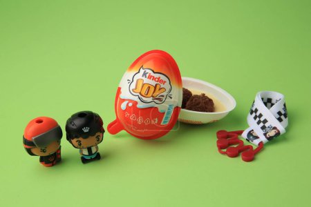 Photo for Sveti Vlas, Bulgaria - June 29, 2023: Halves of Kinder Joy Egg with sweet candies and toys on light green background - Royalty Free Image