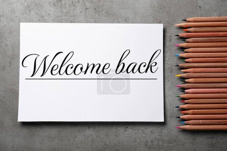 Téléchargez les photos : Papier avec phrase Welcome Back et crayons sur table grise, pose plate - en image libre de droit
