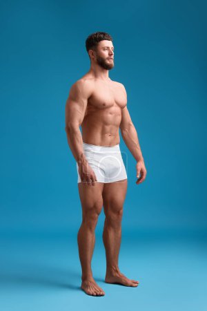 Foto de Hombre musculoso guapo sobre fondo azul claro. Cuerpo sexy - Imagen libre de derechos