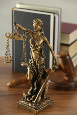 Téléchargez les photos : Figure de Lady Justice, marteau et livres sur table en bois à l'intérieur. Symbole du traitement équitable prévu par la loi - en image libre de droit