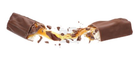 Foto de Barra de chocolate rota con delicioso caramelo en el aire sobre fondo blanco - Imagen libre de derechos