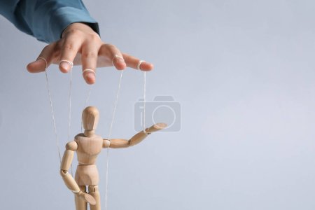 Photo for Woman pulling strings of puppet on light grey background, closeup. Space for text - Royalty Free Image