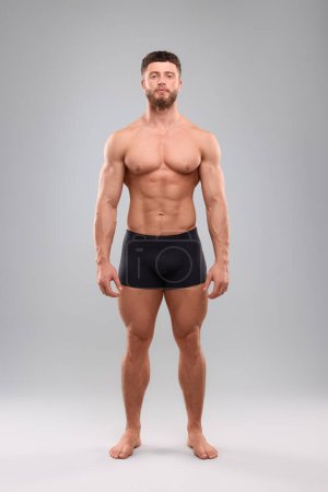 Foto de Hombre musculoso guapo sobre fondo gris claro. Cuerpo sexy - Imagen libre de derechos