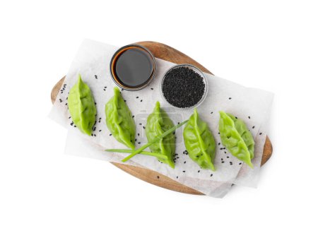 Téléchargez les photos : Délicieuses boulettes vertes (gyozas), sauce soja et graines de sésame isolées sur blanc, vue de dessus - en image libre de droit