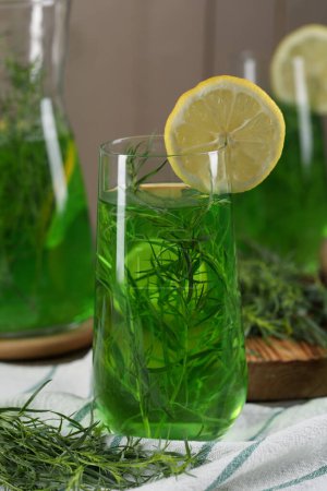 Photo for Glass of refreshing tarragon drink with lemon slice on table - Royalty Free Image