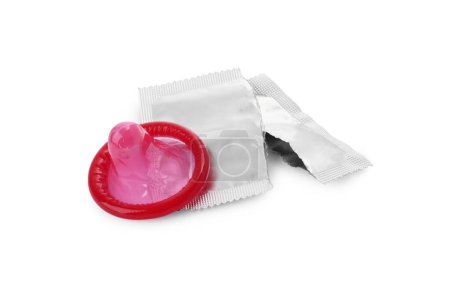 Condón desempaquetado y paquete desgarrado sobre fondo blanco. Sexo seguro