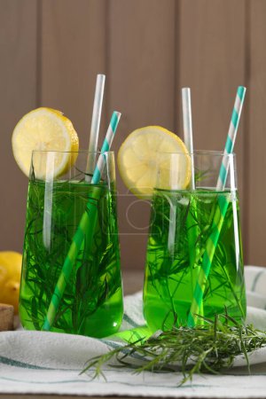Photo for Glasses of refreshing tarragon drink with lemon slices on table - Royalty Free Image