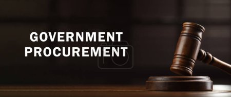 Photo for Government procurement. Wooden gavel on table and text against blurred background, banner design - Royalty Free Image