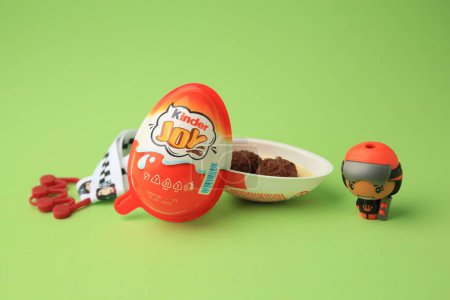 Photo for Sveti Vlas, Bulgaria - June 29, 2023: Halves of Kinder Joy Egg with sweet candies and toys on light green background - Royalty Free Image