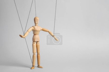 Photo for One wooden puppet with strings on light grey background. Space for text - Royalty Free Image