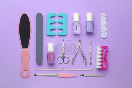 Foto de Juego de herramientas de pedicura sobre fondo violeta, plano - Imagen libre de derechos