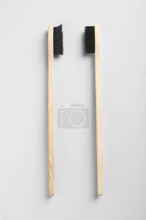 Foto de Cepillos de dientes de bambú viejos y nuevos sobre fondo blanco, plano - Imagen libre de derechos
