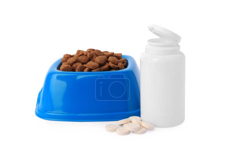 Téléchargez les photos : Aliments secs pour animaux dans un bol, vitamines et bouteille isolés sur blanc - en image libre de droit