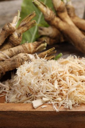 Photo for Grated horseradish and roots on table, closeup - Royalty Free Image