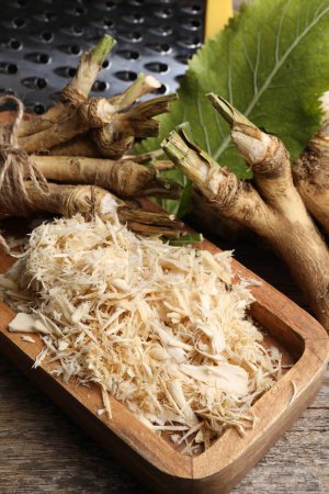 Photo for Grated horseradish and roots on wooden table, above view - Royalty Free Image