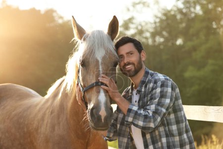 Hombre con un caballo adorable al aire libre en un día soleado. Preciosa mascota domesticada