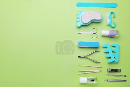 Foto de Juego de herramientas de pedicura sobre fondo verde claro, plano. Espacio para texto - Imagen libre de derechos