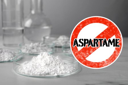Photo for Prohibition sign with word Aspartame symbolizing restriction on use of sugar substitute. Artificial sweetener in Petri dishes on gray table - Royalty Free Image