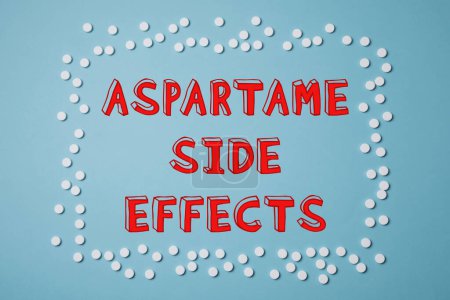 Téléchargez les photos : Aspartame effets secondaires. Tablettes de substitution de sucre encadrant le texte sur fond bleu clair, vue du dessus - en image libre de droit