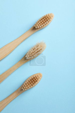 Foto de Cepillos de dientes de bambú sobre fondo azul claro, plano - Imagen libre de derechos