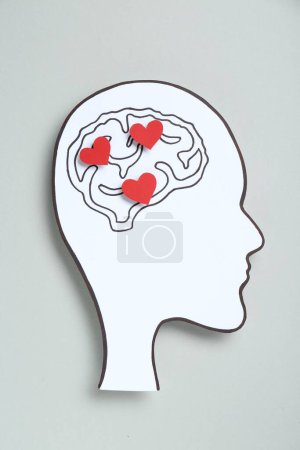 Photo for Emotional thinking. Paper human head cutout with drawing of brain and red hearts on grey background, top view - Royalty Free Image