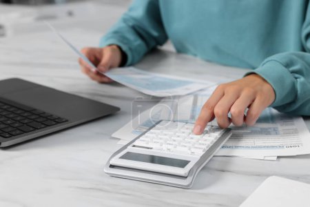 Téléchargez les photos : Femme calculant les impôts à la table blanche, gros plan - en image libre de droit