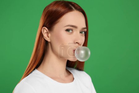 Photo for Beautiful woman blowing bubble gum on green background, space for text - Royalty Free Image