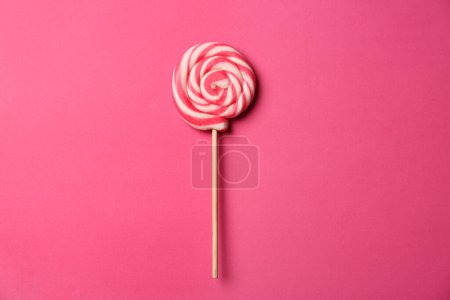 Téléchargez les photos : Bâton avec sucette sucrée savoureuse sur fond rose, vue de dessus - en image libre de droit