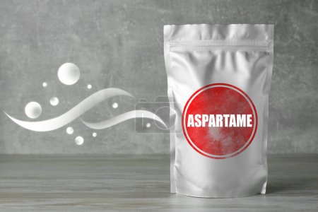 Photo for Aspartame. Foil package with artificial sweetener on gray wooden table - Royalty Free Image