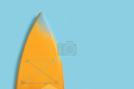 Photo for One SUP board on light blue background, top view with space for text. Water sport - Royalty Free Image