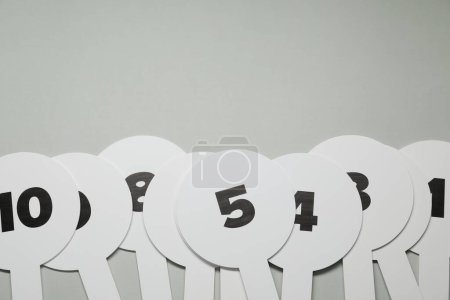 Photo for Auction paddles with numbers on light grey background, flat lay. Space for text - Royalty Free Image