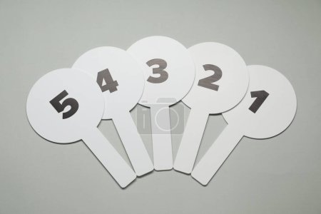 Photo for Auction paddles with numbers on light grey background, flat lay - Royalty Free Image