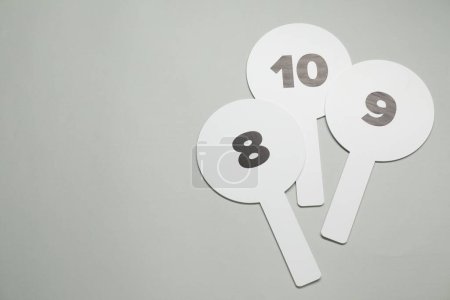 Photo for Auction paddles with numbers on light grey background, flat lay. Space for text - Royalty Free Image