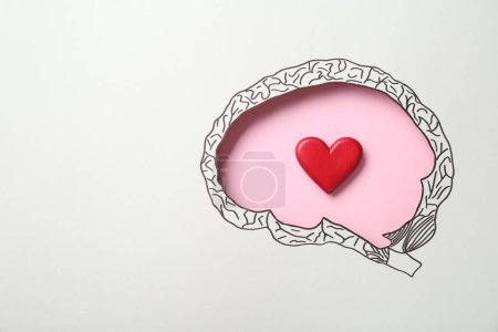 Photo for Emotional thinking. Red heart on pink background, top view through paper with brain shaped hole and drawing. Space for text - Royalty Free Image
