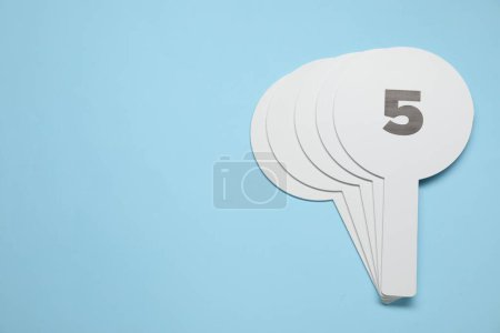 Photo for Auction paddles on light blue background, top view. Space for text - Royalty Free Image