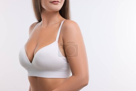 Téléchargez les photos : Femme avec une belle poitrine sur fond blanc, gros plan. Espace pour le texte - en image libre de droit