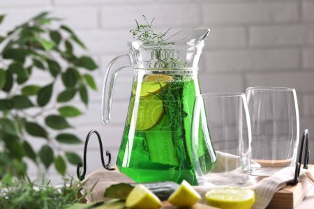 Photo for Jug of homemade refreshing tarragon drink and glasses on table - Royalty Free Image