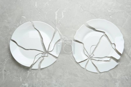 Photo for Two broken ceramic plates on light grey table, flat lay - Royalty Free Image