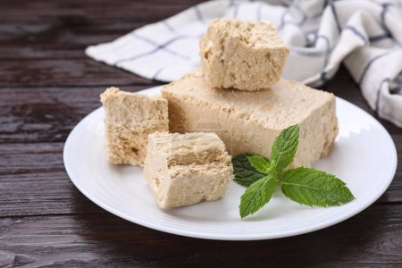 Photo for Plate with pieces of tasty halva and mint on wooden table, closeup - Royalty Free Image