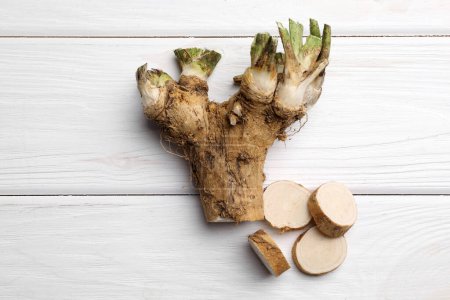 Photo for Cut horseradish root on white wooden table, flat lay - Royalty Free Image