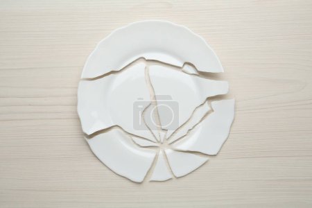 Photo for Pieces of broken ceramic plate on white wooden table, flat lay - Royalty Free Image