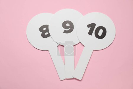 Photo for Auction paddles with numbers on pink background, top view - Royalty Free Image