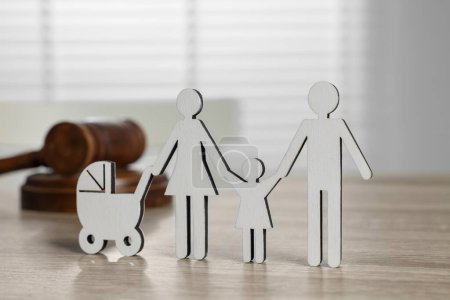 Téléchargez les photos : Droit de la famille. Figure des parents avec enfants et marteau sur table en bois clair - en image libre de droit