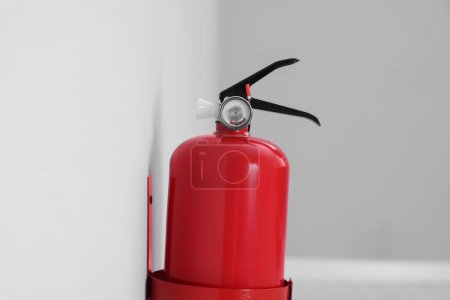Photo for Red fire extinguisher on light grey wall - Royalty Free Image