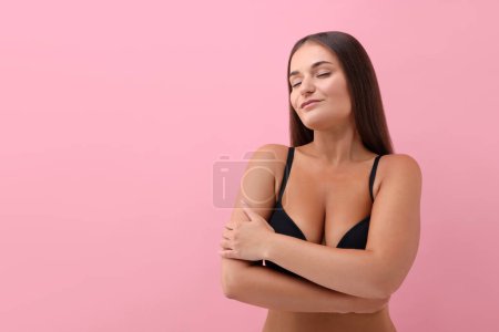 Téléchargez les photos : Portrait de jeune femme avec un beau sein sur fond rose. Espace pour le texte - en image libre de droit