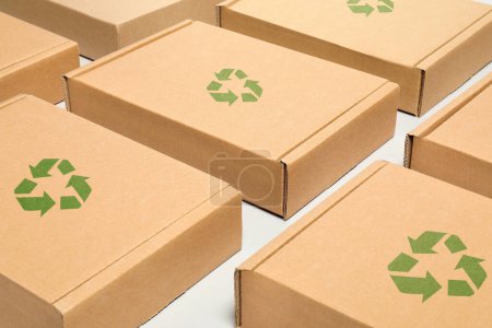 Boîtes en carton avec timbres de recyclage sur fond blanc