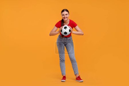Photo for Happy soccer fan with ball on orange background - Royalty Free Image