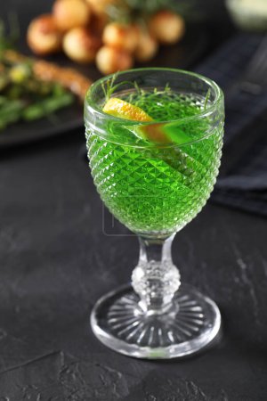 Photo for Delicious drink with tarragon in glass on dark textured table - Royalty Free Image