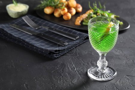 Photo for Delicious drink with tarragon in glass on dark textured table. Space for text - Royalty Free Image
