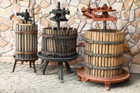 Foto de Vinos de metal en barriles de madera cerca de la pared de piedra al aire libre - Imagen libre de derechos
